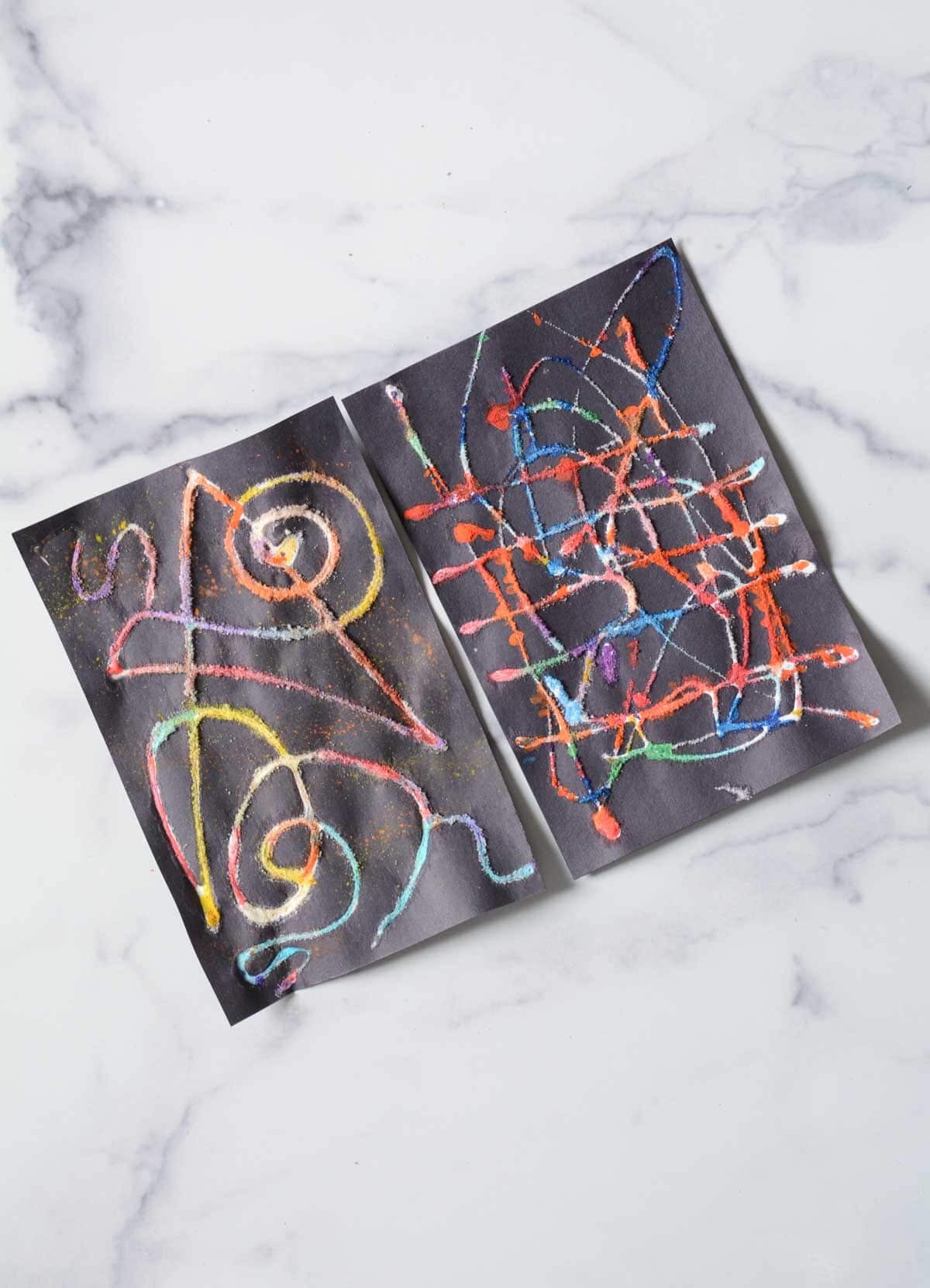 raised salt paintings on black paper.