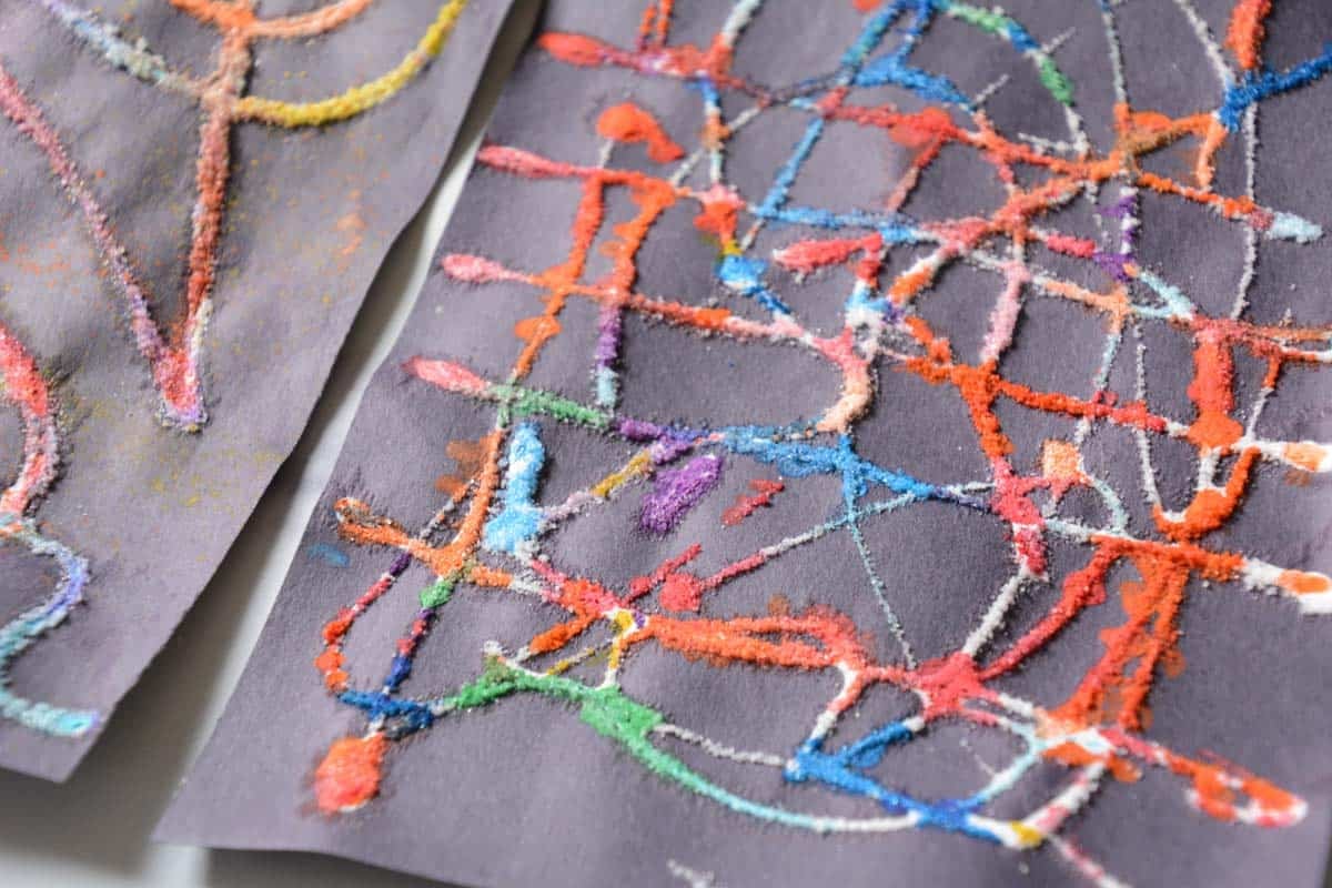 close-up view of salt and watercolor lines on black paper.