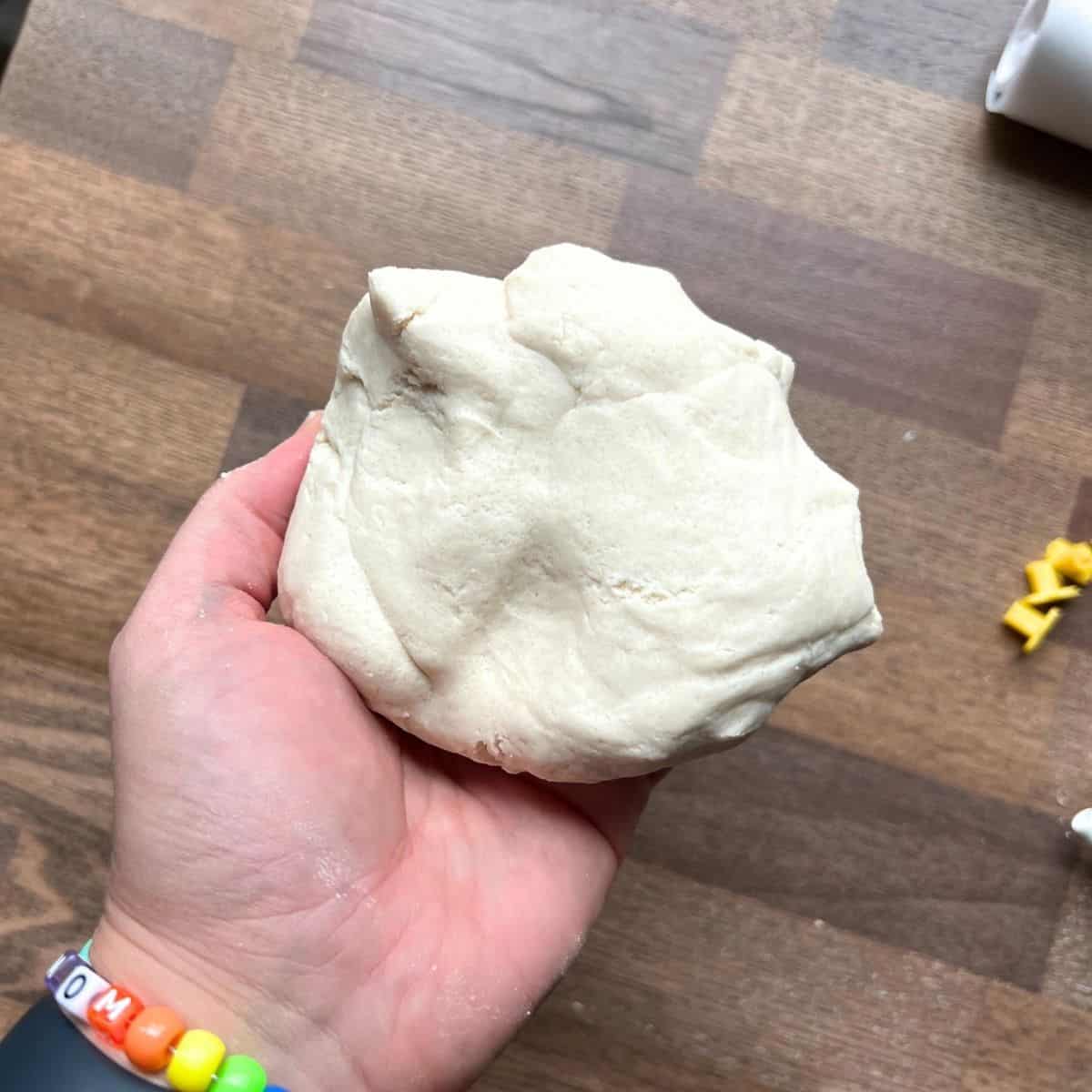 hand holding white dough.