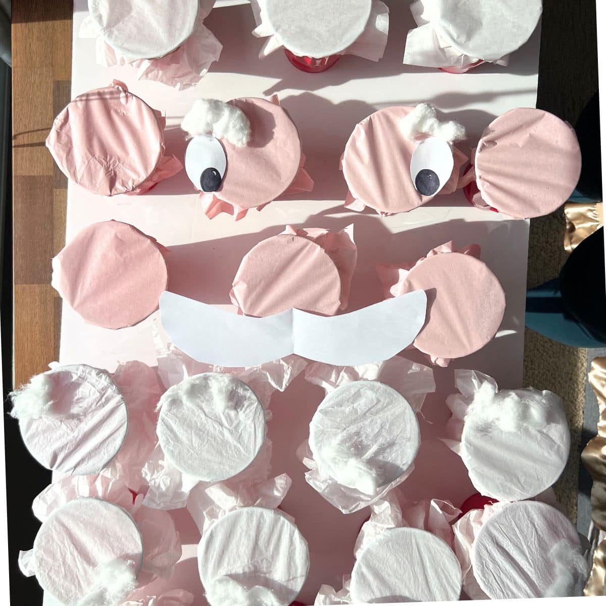 plastic cups covered with tissue paper and white paper eyes added on.