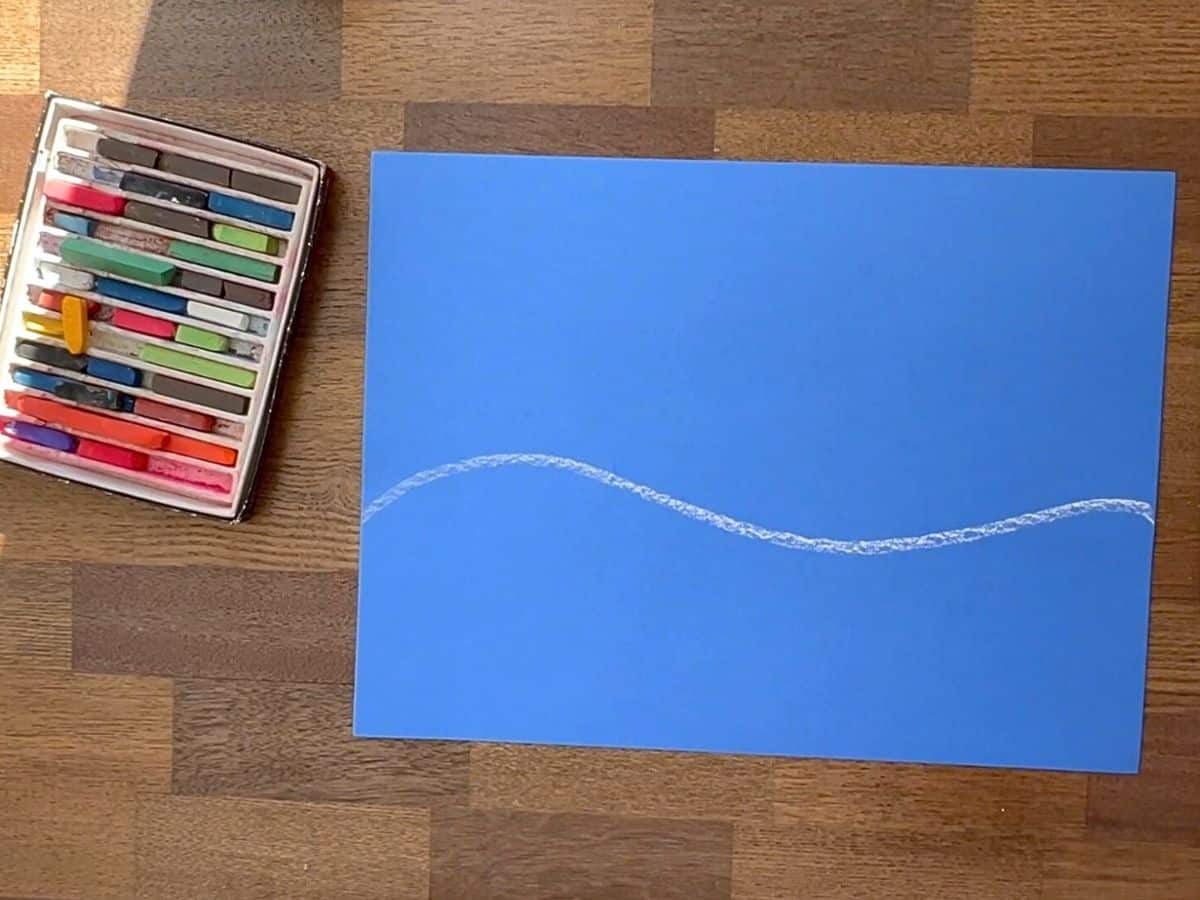 blue paper with white chalk line drawn.