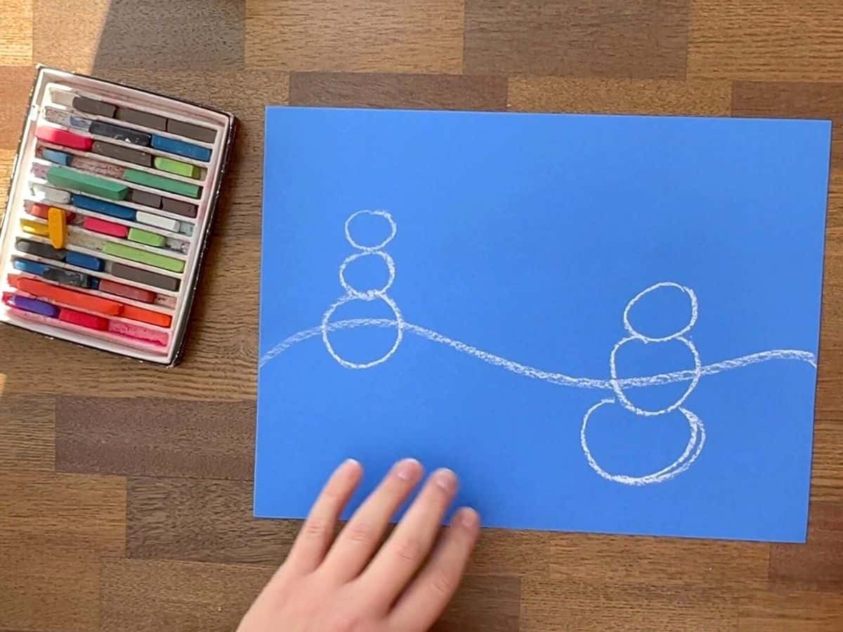 white chalk circle drawing on blue paper.