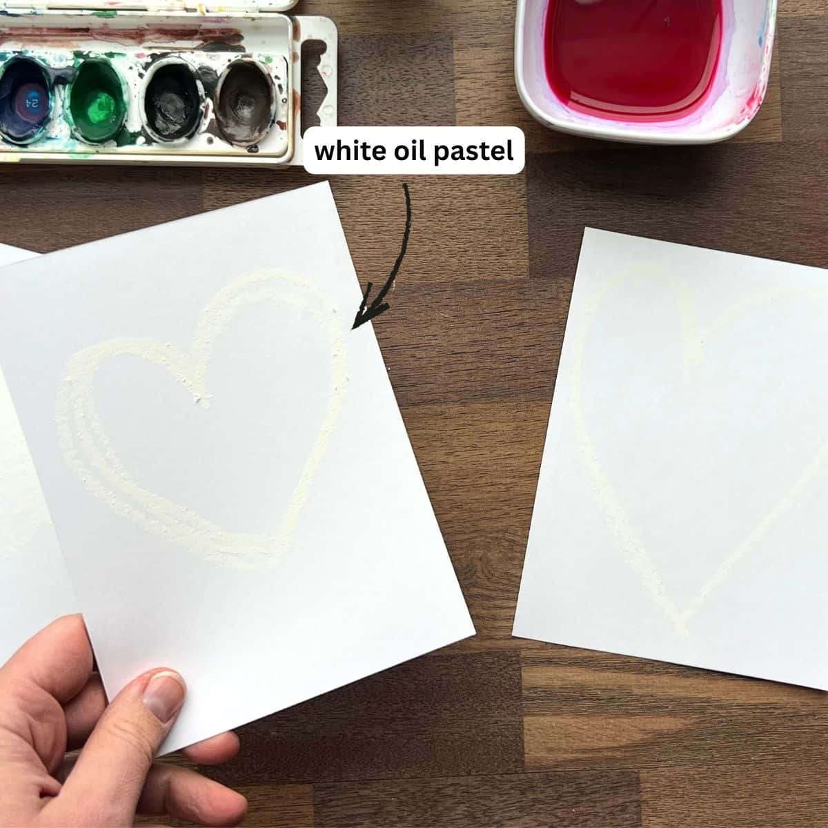 white oil pastel heart drawn on white paper.