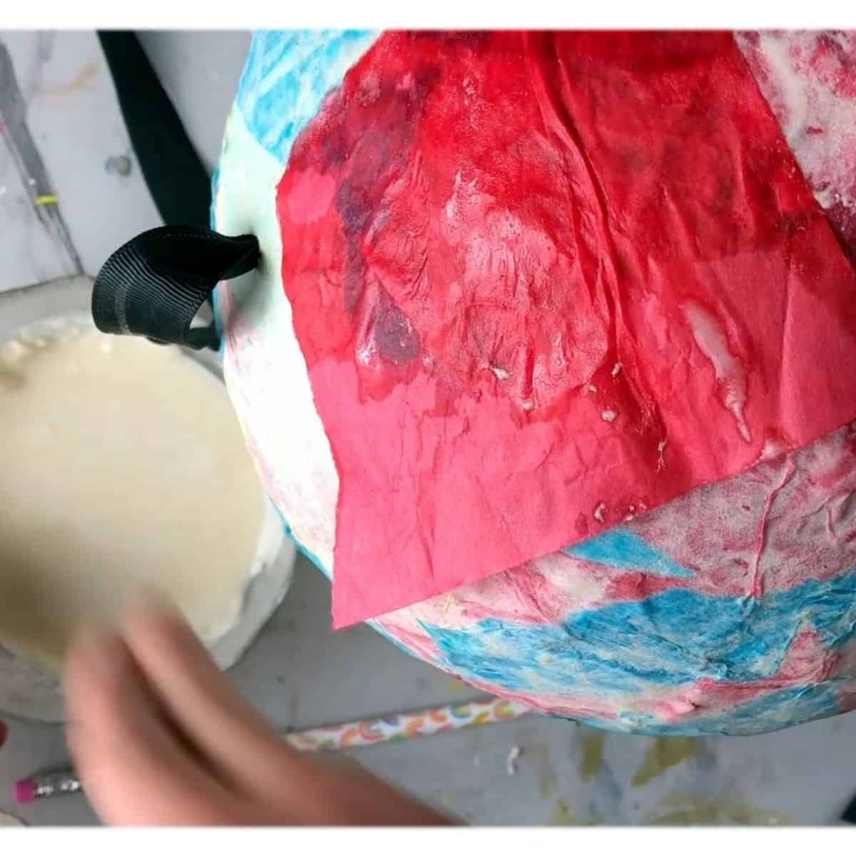 new tissue paper on top of paper mache balloon pinata.