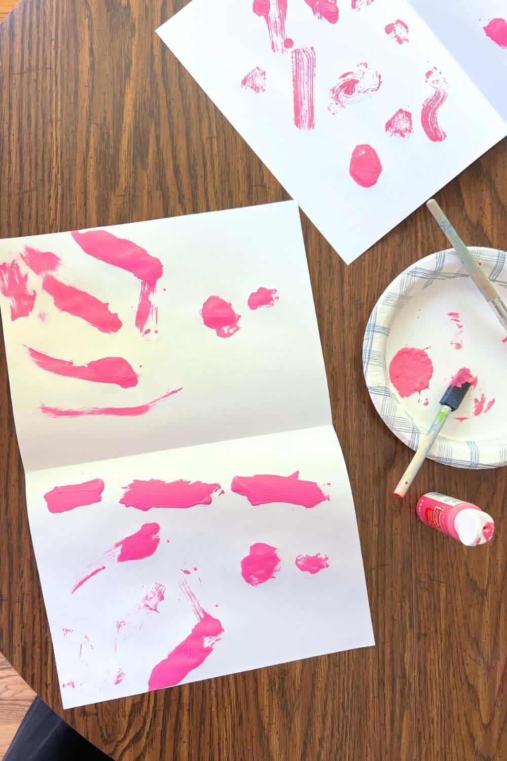 pink paint on a folded white paper.