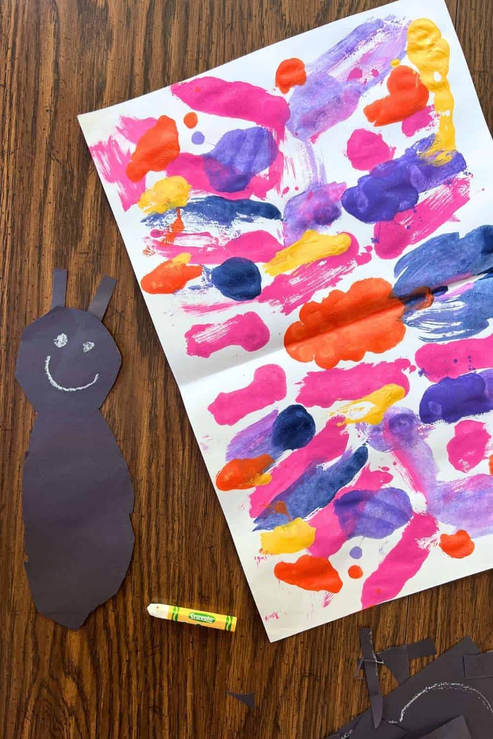 folded painted paper with a black paper with a smile on it.