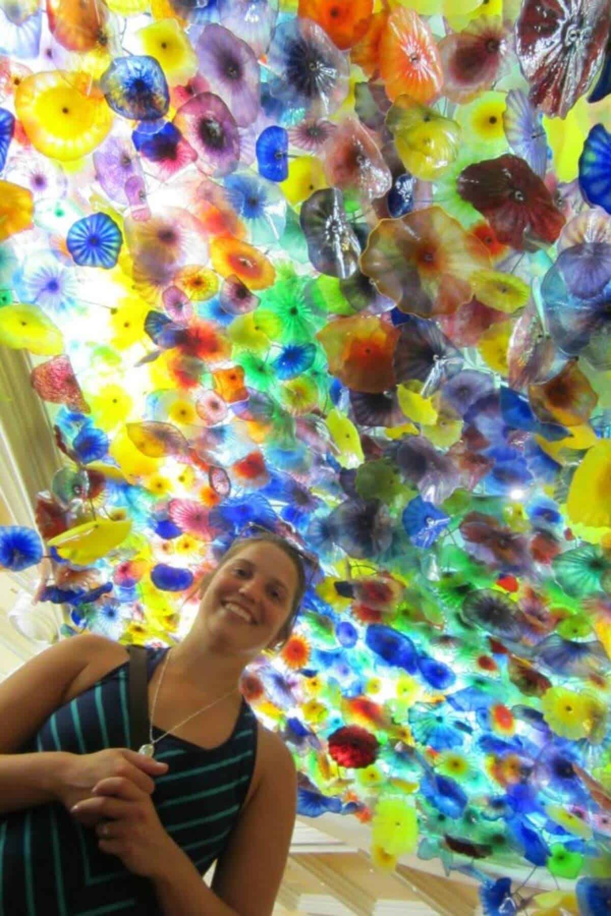 woman standing in front of the Bellagio glass sculpture ceiling.
