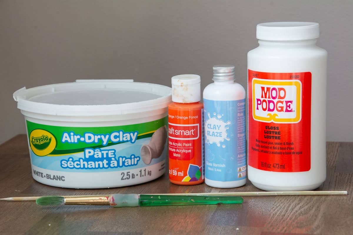 air dry clay, paint, clear glaze, Mod podge and brush on a table.