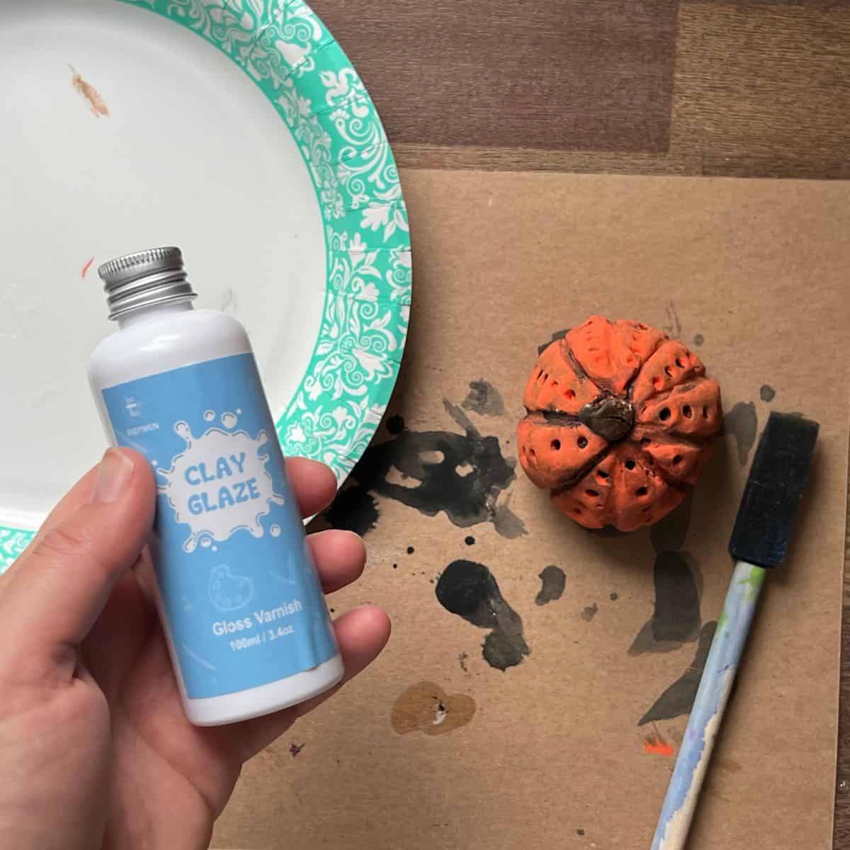 hand holding clear glaze sealer.