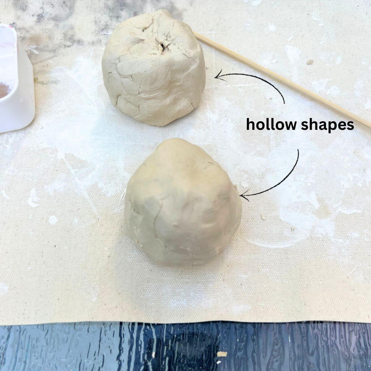 two hollow clay balls on a table.