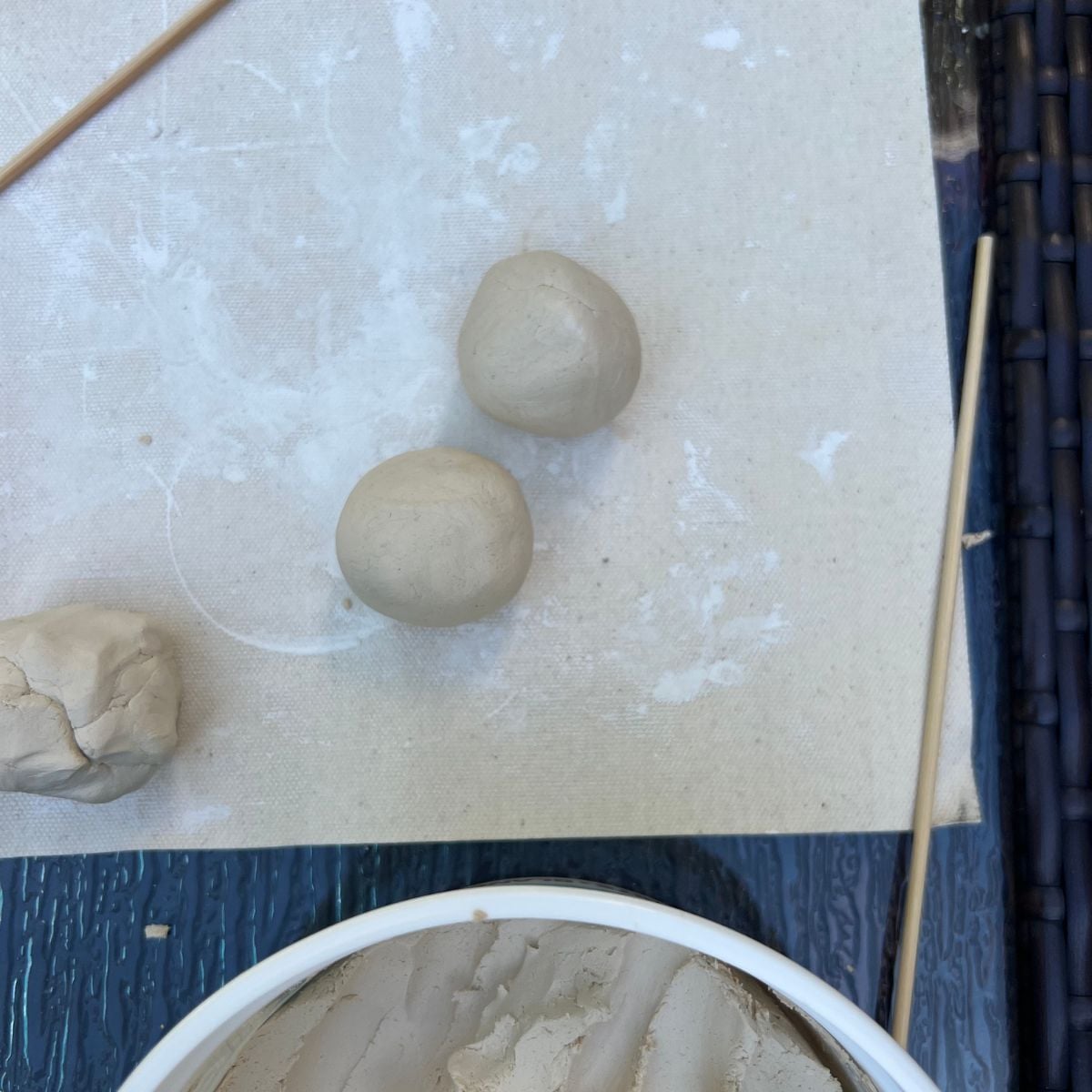two balls of air dry clay on a mat.