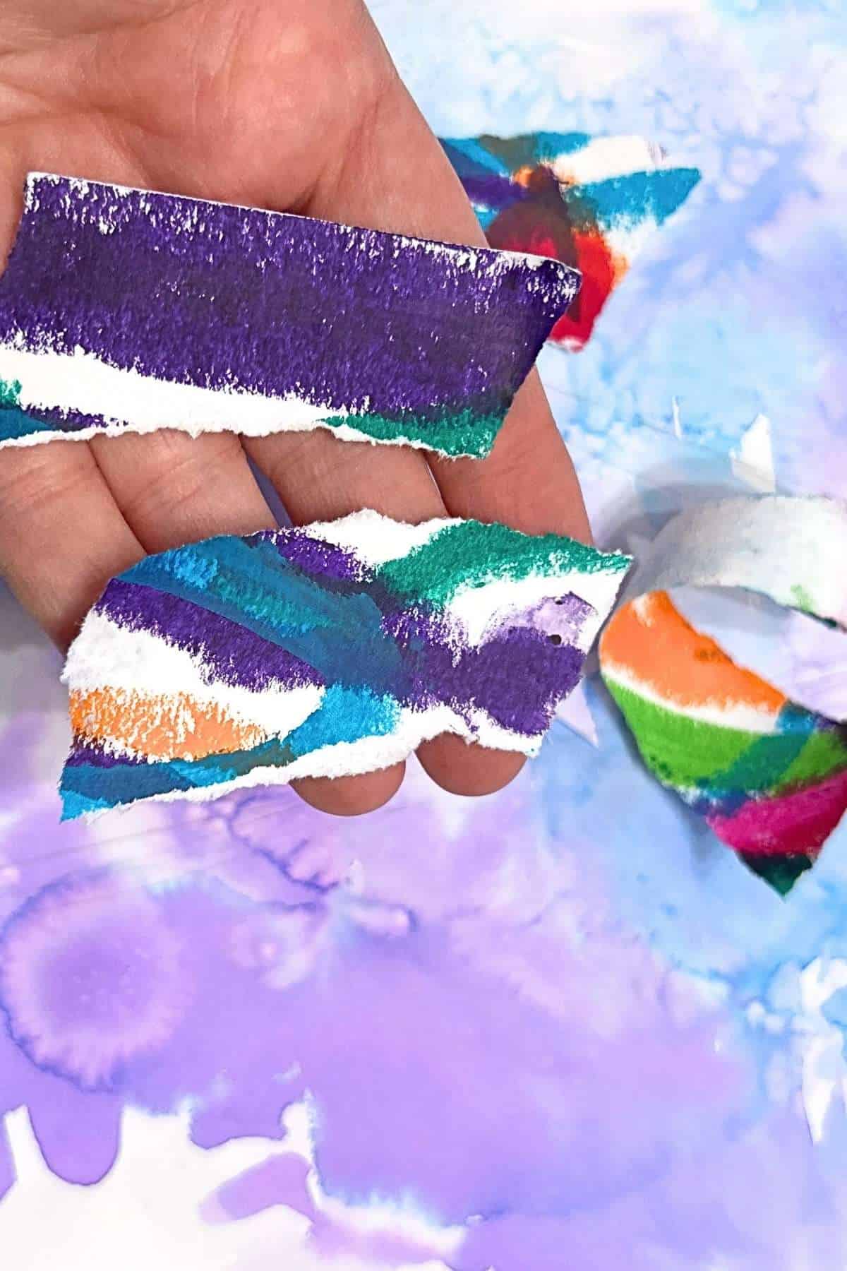 hand holding colorful ripped paper.