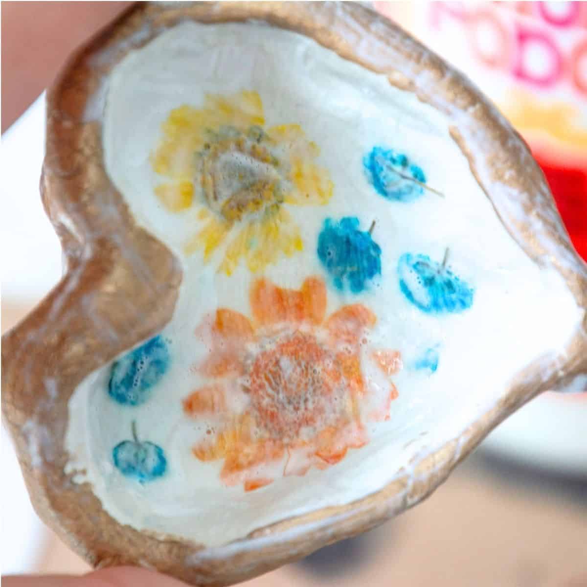 mod podge layer on top of flower in clay dish.